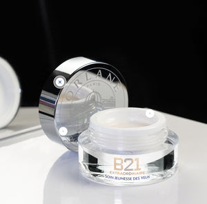 Orlane B21 Extraordinaire Eye Cream open on a reflective surface with luxury silver lid in background