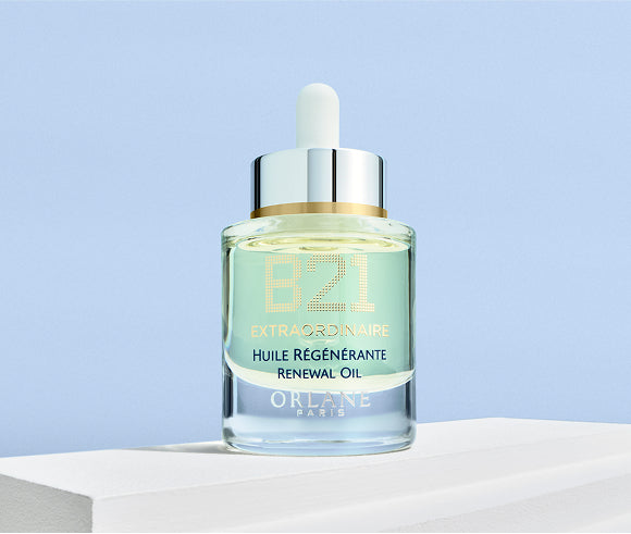 Orlane B21 Extraordinaire Renewal Oil in a glass dropper bottle placed on a white surface with light blue background